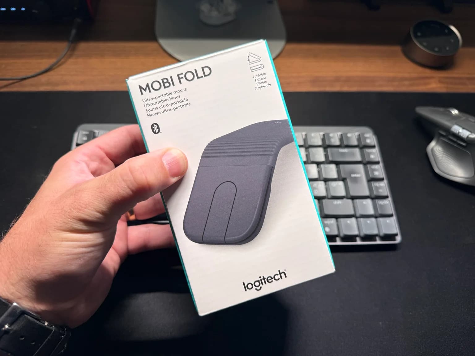 Förpackningen till Logitech Mobi Fold framför ett tangentbord på ett skrivbord.