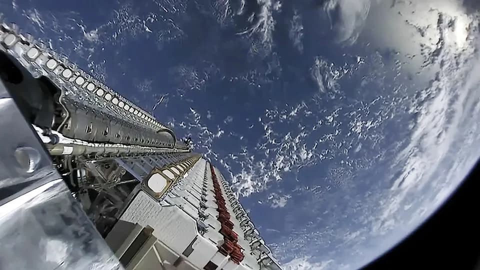 Två staplar med Starlink-satelliter på en rakets övre steg, med jordens hav och moln i bakgrunden. Arkivbild från maj 2019.