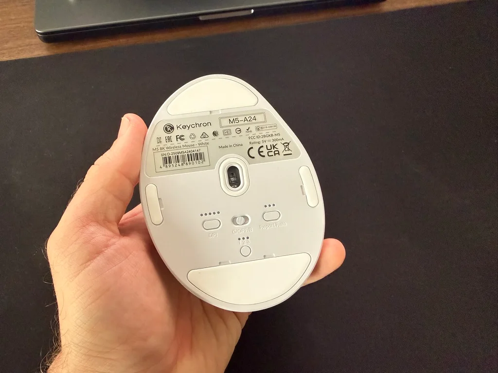 Undersidan av Keychron M5 8K med sensor, DPI-knapp och reglage för anslutning och pollingfrekvens.