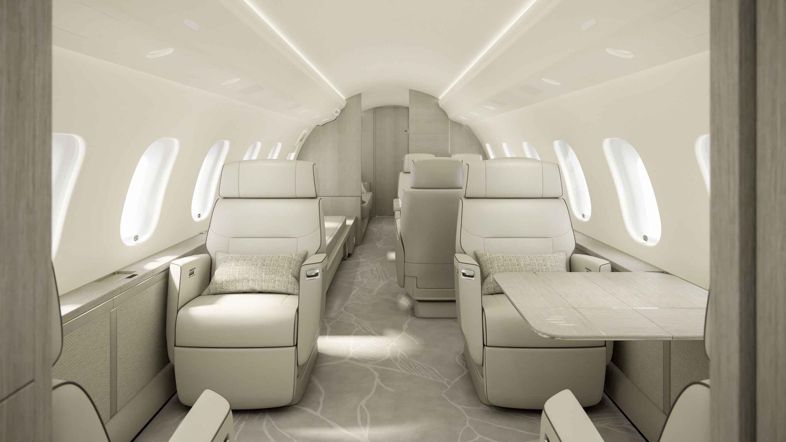 En ljus sittgrupp i kabinen på en Bombardier Global 6500 med soffa, fåtölj, bord och stora fönster.